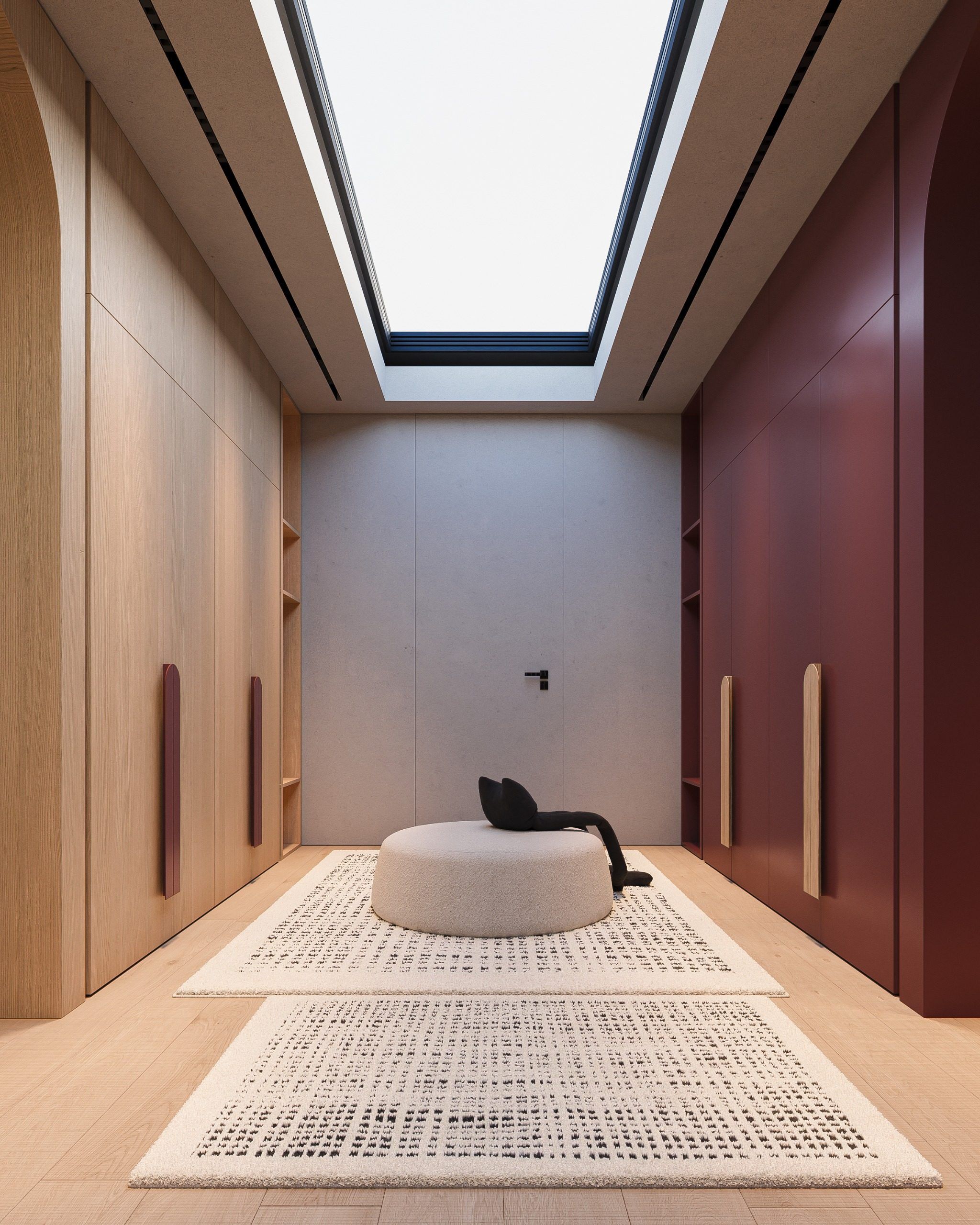 Symmetrical room with cabinetry on both walls, round bed and overhead skylight