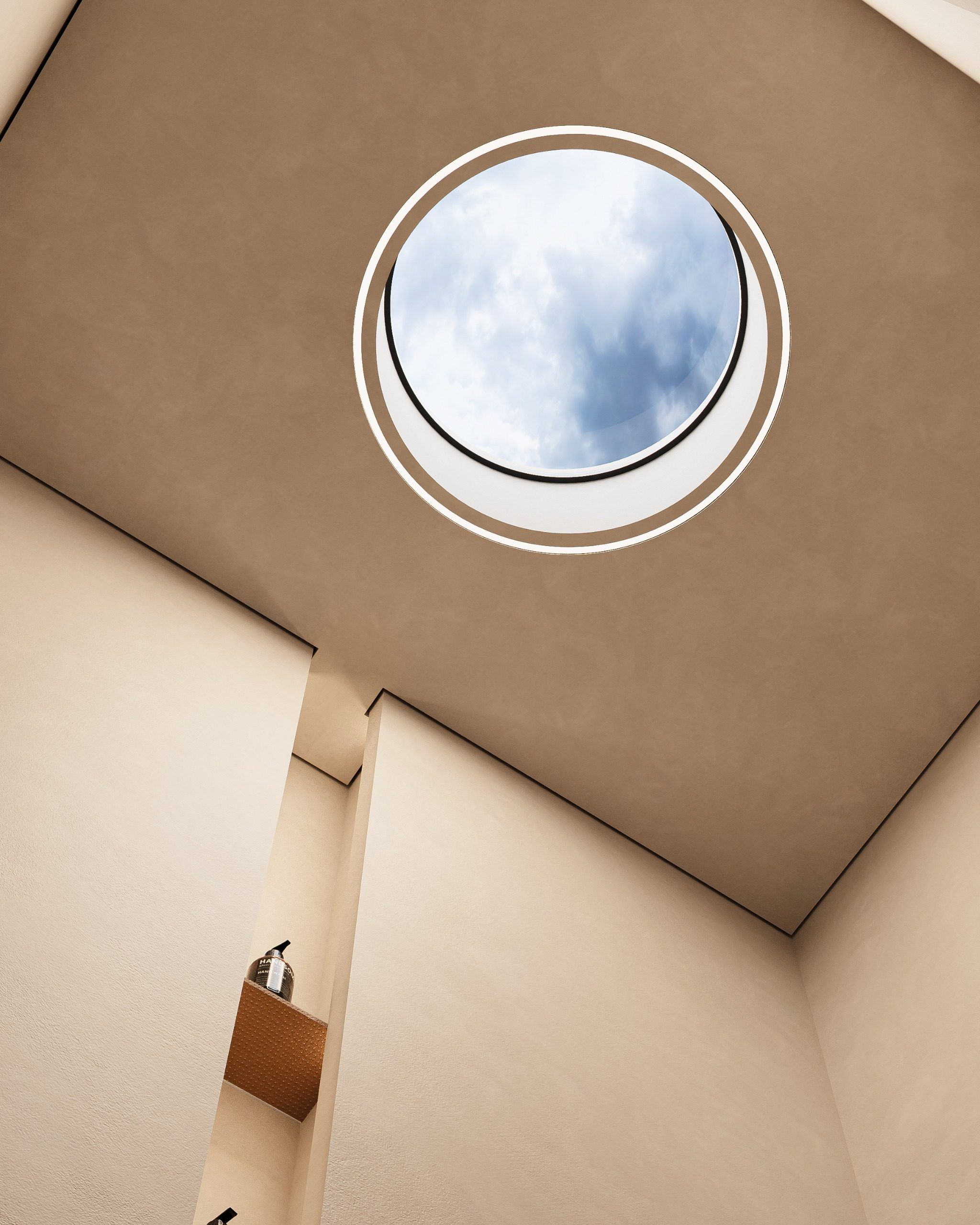 Round skylight in angled ceiling with view of cloudy sky